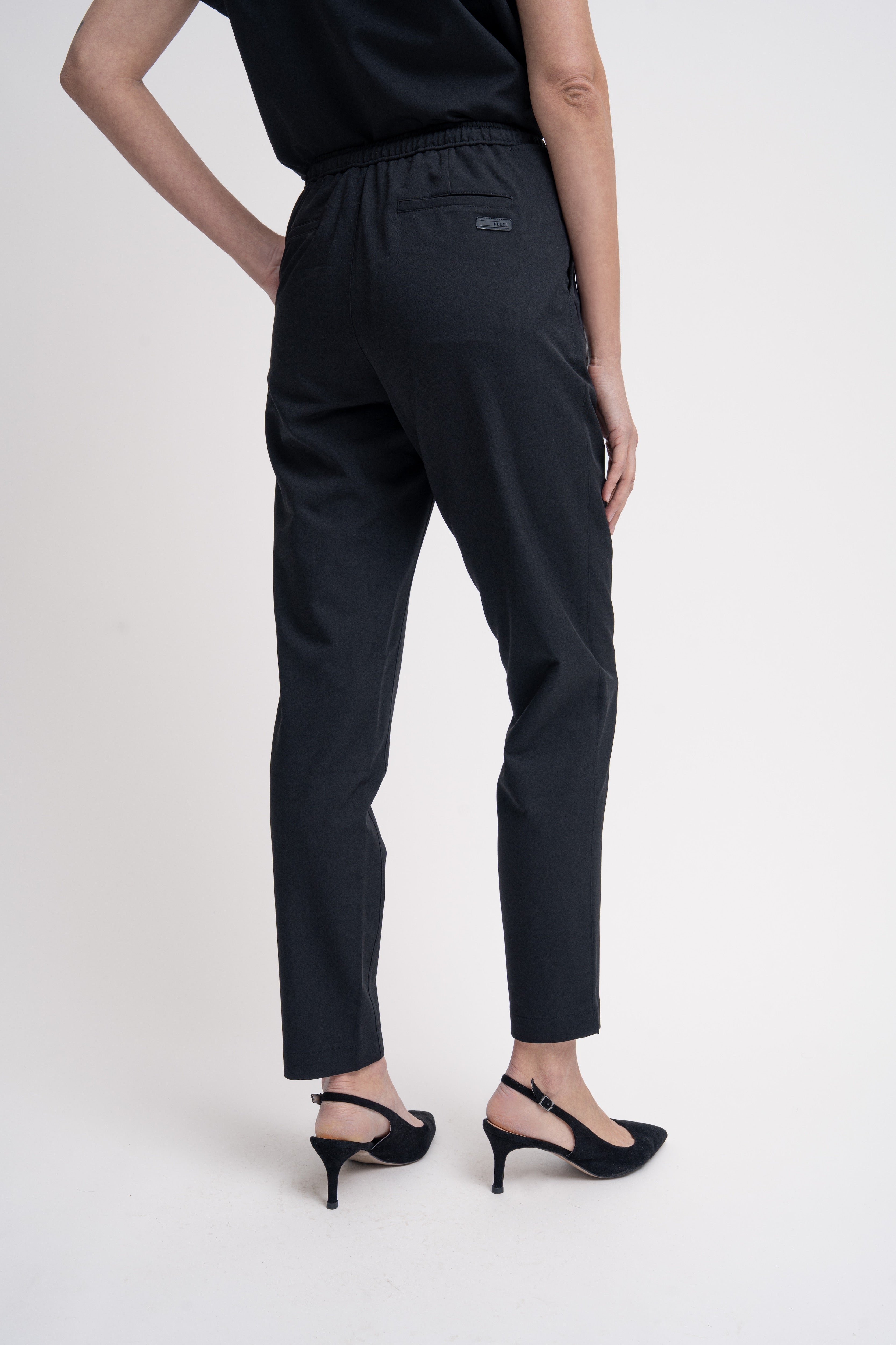 Women's scrub pant in black, back view, half body.