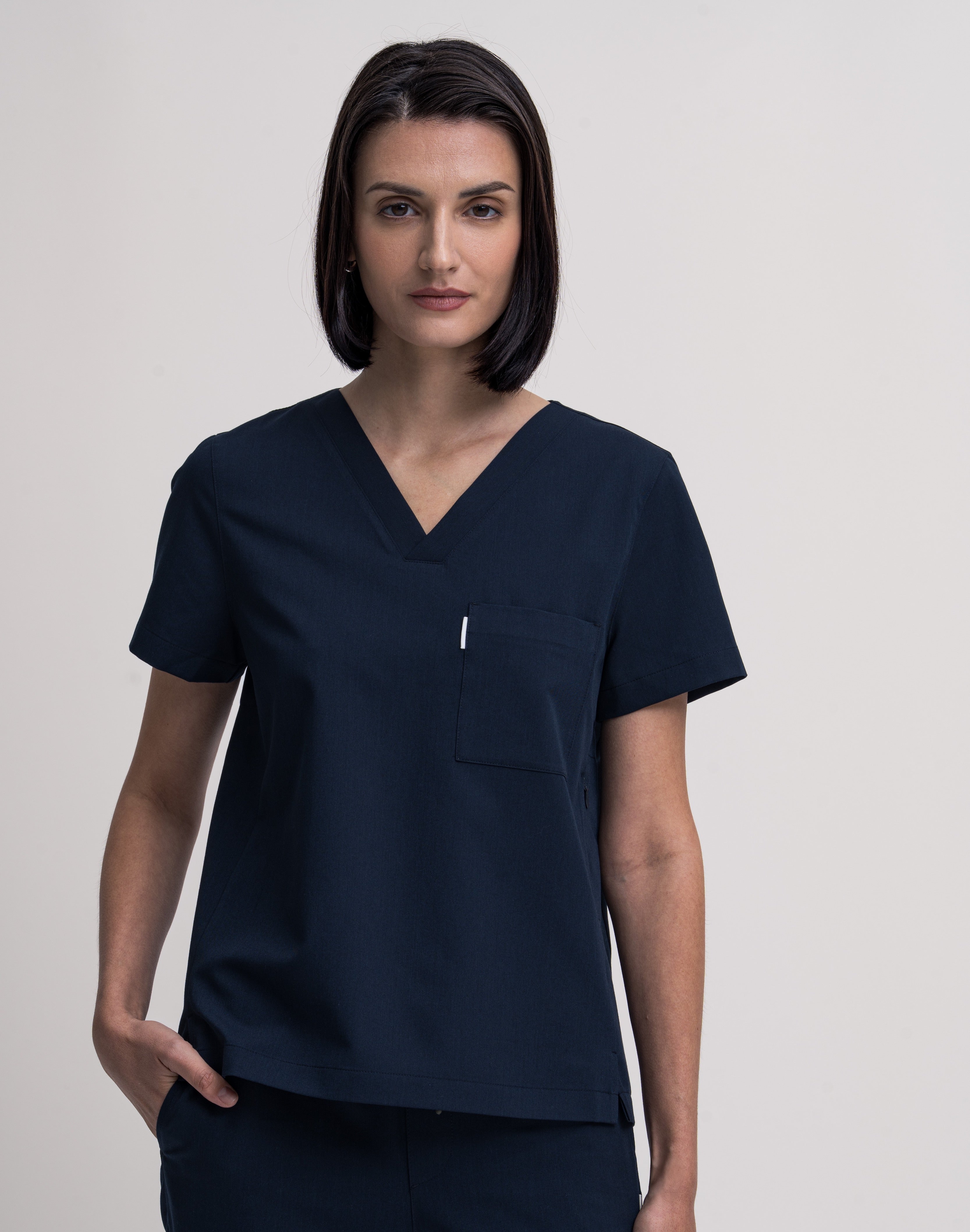 Women's V-neck scrub top in navy, front view, quarter body.