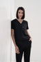 Women's scrub pant in black, styled half body view.