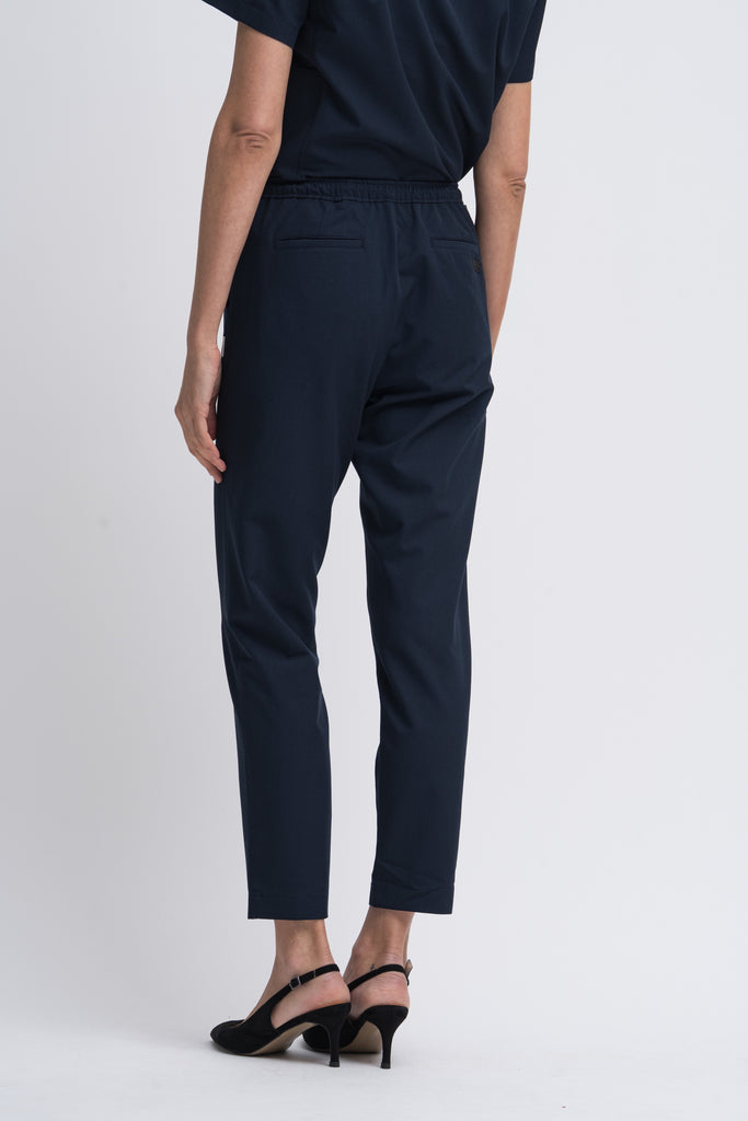 Women's scrub pant in navy, back view, half body.