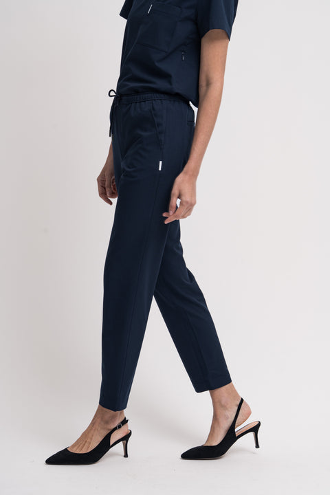 Women's scrub pant in navy, front view, half body.