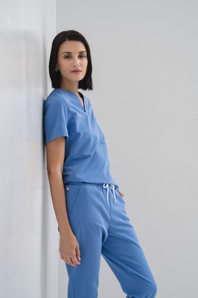 Women's scrub pant in Sailor Blue, styled half body view.