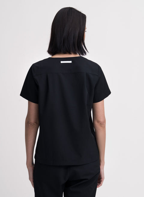 Women's V-neck scrub top in black, back view, quarter body.