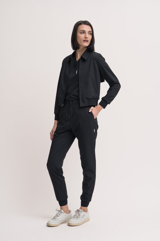 Women's V-neck scrub top in black, front view, full body.